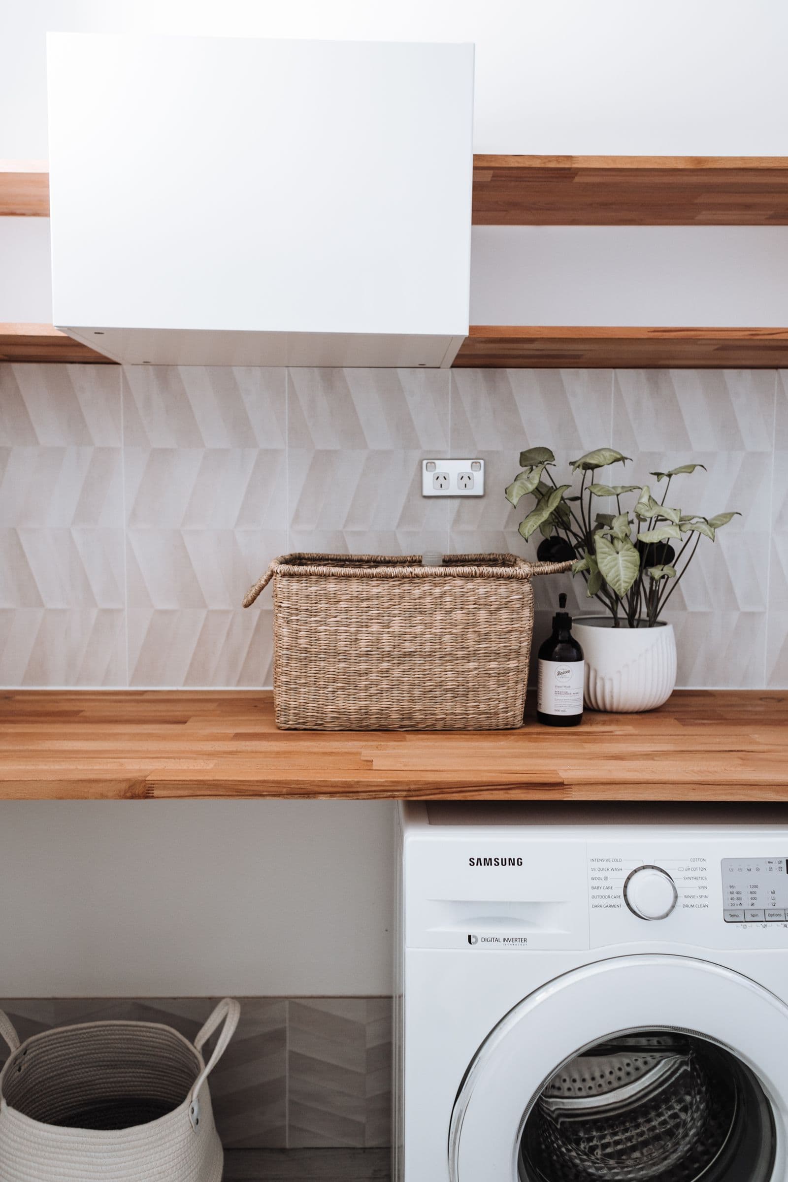Bright utility room with washing machine under a wooden worktop